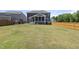 Large backyard with a covered patio, lush green grass, and privacy fencing for outdoor enjoyment at 2527 Sidewinder Ct, Apex, NC 27523