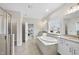 Spacious bathroom featuring a soaking tub, separate shower, and large mirrors for an open feel at 2527 Sidewinder Ct, Apex, NC 27523