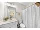 This well-lit bathroom features a vanity with sink, toilet, and a shower with a decorative shower curtain at 2527 Sidewinder Ct, Apex, NC 27523