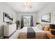 Stylish bedroom featuring a large window, a dresser, and neutral decor at 2527 Sidewinder Ct, Apex, NC 27523