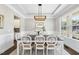 Elegant dining room with stylish lighting, wainscoting, and ample natural light from the window at 2527 Sidewinder Ct, Apex, NC 27523