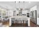 Bright kitchen boasts white cabinets, stainless steel appliances, and a granite island with seating at 2527 Sidewinder Ct, Apex, NC 27523