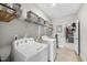 Bright laundry room with washer, dryer, and shelving for storage and organization at 2527 Sidewinder Ct, Apex, NC 27523