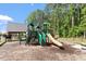 Community playground amidst a wooded area, featuring a slide and climbing structures at 2527 Sidewinder Ct, Apex, NC 27523