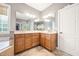 Bright bathroom with a double sink vanity, large mirror and a separate bathtub at 2728 Cameron Pond Dr, Cary, NC 27519