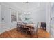 Formal dining room with elegant wainscoting, hardwood floors, and a modern chandelier at 2728 Cameron Pond Dr, Cary, NC 27519