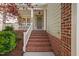 Inviting front entrance with brick steps, charming porch, and beautifully painted door at 2728 Cameron Pond Dr, Cary, NC 27519