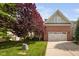Charming brick home features a two-car garage, beautiful landscaping, and a well-manicured lawn at 2728 Cameron Pond Dr, Cary, NC 27519