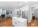 Spacious kitchen view into the living room featuring white cabinetry, stainless steel appliances, and a marble countertop island at 2728 Cameron Pond Dr, Cary, NC 27519
