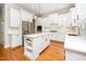 Modern kitchen with white cabinets, island, stainless steel appliances, and hardwood floors at 2728 Cameron Pond Dr, Cary, NC 27519