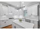 Bright kitchen features white cabinets, stainless steel appliances, and a marble countertop island with modern pendant lights at 2728 Cameron Pond Dr, Cary, NC 27519