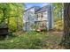 Backyard view of a light blue two-story house surrounded by lush greenery and mature trees at 307 Durington Pl, Cary, NC 27518