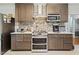 Well-equipped kitchen boasting dark wood cabinets, stone backsplash, and modern stainless-steel appliances at 307 Durington Pl, Cary, NC 27518