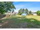 This backyard is fenced in and features a grassy area, trees, and a blue trampoline at 311 Ocean Dr, Clayton, NC 27520