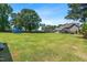 A well-maintained, spacious backyard with a fenced perimeter and mature trees at 311 Ocean Dr, Clayton, NC 27520