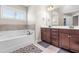 Bathroom features a soaking tub, dark wood cabinets, and a double vanity at 311 Ocean Dr, Clayton, NC 27520
