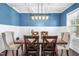 Charming dining room featuring blue walls, white wainscoting, coffered ceilings, and a dark wood table at 311 Ocean Dr, Clayton, NC 27520