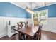 Charming dining room featuring blue walls, white wainscoting, coffered ceilings, and a dark wood table at 311 Ocean Dr, Clayton, NC 27520