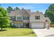 Traditional two-story home with a two car garage, a basketball hoop, and well-maintained landscaping at 311 Ocean Dr, Clayton, NC 27520