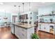 Bright kitchen featuring white cabinets, granite countertops, stainless appliances, and an island with seating at 311 Ocean Dr, Clayton, NC 27520