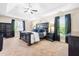 This main bedroom features dark furnishings, tray ceiling, and carpeted floors at 311 Ocean Dr, Clayton, NC 27520