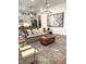 Open-concept living room featuring a gray sofa, wooden coffee table, and stainless steel appliances at 3521 Olive Glen Dr, Apex, NC 27502