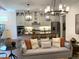 Open-concept living room and kitchen with modern lighting, island seating, and stainless steel appliances at 3521 Olive Glen Dr, Apex, NC 27502