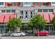 Street view of a modern building with large windows and red awnings providing shade on a sunny day at 400 W North St # 1134, Raleigh, NC 27603