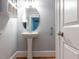 Bathroom featuring pedestal sink, oval mirror, wood baseboards, and white door at 412 Waterford Lake Dr, Cary, NC 27519