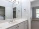 Well-lit bathroom featuring a large mirror, contemporary sink, and view into the bedroom and laundry area at 412 Waterford Lake Dr, Cary, NC 27519