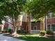 Brick condo building exterior with green space and mature shade trees creating an inviting atmosphere at 412 Waterford Lake Dr, Cary, NC 27519