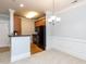 Eat-in kitchen features black appliances, hardwood cabinets, granite countertops and chandelier lighting in dining area at 412 Waterford Lake Dr, Cary, NC 27519