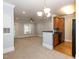 Living room view highlights an open layout to kitchen, featuring neutral carpet and modern lighting fixtures at 412 Waterford Lake Dr, Cary, NC 27519