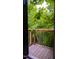 Outdoor balcony with wooden planks and black railings, offering a peaceful view of lush green trees at 42 Miry Branch Ct, Garner, NC 27529