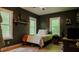 Bright bedroom featuring two windows, dark walls, light wood floors, and desk space at 42 Miry Branch Ct, Garner, NC 27529