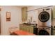 Well-equipped laundry room boasts modern stacked washer/dryer units and ample cabinet storage at 42 Miry Branch Ct, Garner, NC 27529