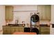 Spacious laundry room featuring custom cabinets, a utility sink, and a modern washer/dryer set at 42 Miry Branch Ct, Garner, NC 27529
