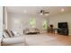 Open living room with hardwood floors, ceiling fan, and a gray sofa at 42 Miry Branch Ct, Garner, NC 27529