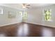 Spacious bedroom with gleaming hardwood floors, a ceiling fan, and sunny windows at 425 Shadow Falls Dr, Wendell, NC 27591