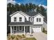Charming two-story home featuring a covered front porch, a two-car garage, and professional landscaping at 425 Shadow Falls Dr, Wendell, NC 27591