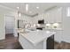 Contemporary kitchen with a large island, white cabinets, stainless appliances, and marble backsplash at 425 Shadow Falls Dr, Wendell, NC 27591