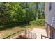 Serene backyard with green lawn, mature trees, and a patio accessible by stairs at 4300 Edgehill Ct, Raleigh, NC 27612