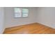 Cozy bedroom featuring hardwood flooring and a sunlit window with views of the tree line at 4300 Edgehill Ct, Raleigh, NC 27612
