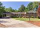 Charming brick home with a well-manicured lawn and a convenient carport, surrounded by lush greenery at 4300 Edgehill Ct, Raleigh, NC 27612