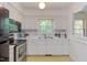 Well-lit kitchen features white cabinets, stainless steel appliances, and a window view at 4300 Edgehill Ct, Raleigh, NC 27612