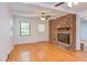 Living room boasts hardwood floors, ceiling fans, and a brick fireplace with decor at 4300 Edgehill Ct, Raleigh, NC 27612