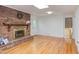 Relaxing living room with brick fireplace, light hardwood floors, and view to backyard at 4300 Edgehill Ct, Raleigh, NC 27612