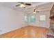 Bright living room featuring hardwood floors, ceiling fans, and a brick fireplace at 4300 Edgehill Ct, Raleigh, NC 27612