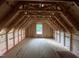 New construction attic space with exposed rafters and a centered window for natural light at 5021 Mitchell Town Rd, Youngsville, NC 27596
