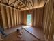 Unfinished bedroom showing wood framing with a large window during the construction phase at 5021 Mitchell Town Rd, Youngsville, NC 27596